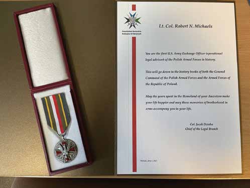 Upon completion of his tour as the first U.S. Army exchange officer to Poland, LTC Robert N. Michaels
        was awarded the Silver Polish Army Medal and a certificate from the Chief of the General Command
        Legal Division. (Photo courtesy of authors)